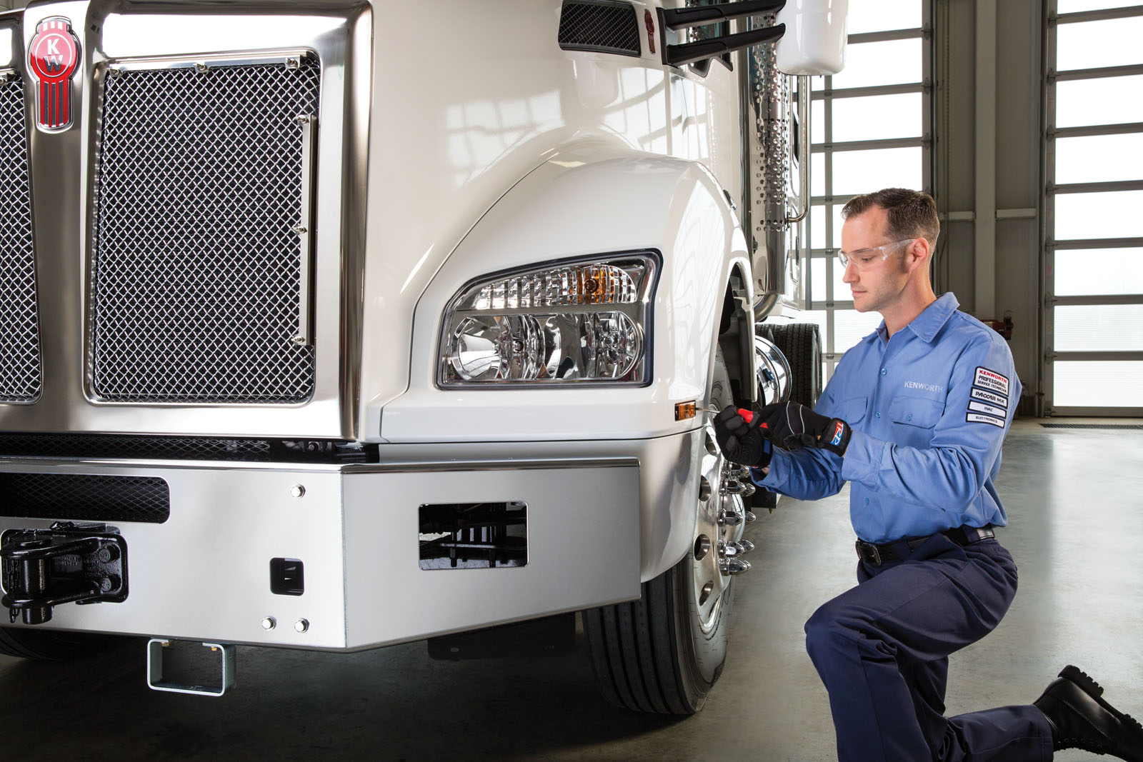 Kenworth mechanic adjusting turn signal light inside garage