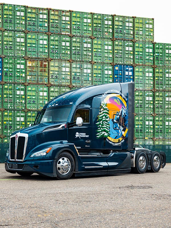 Capitol Christmas Tree Custom Kenworth Truck in front of cargo containers