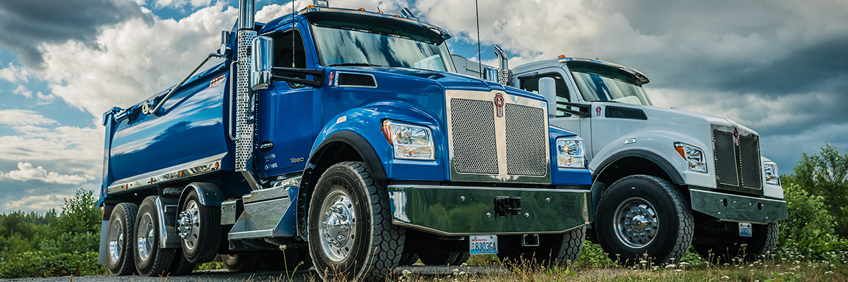 Closeup of two Kenworth T880 trucks parked on a field