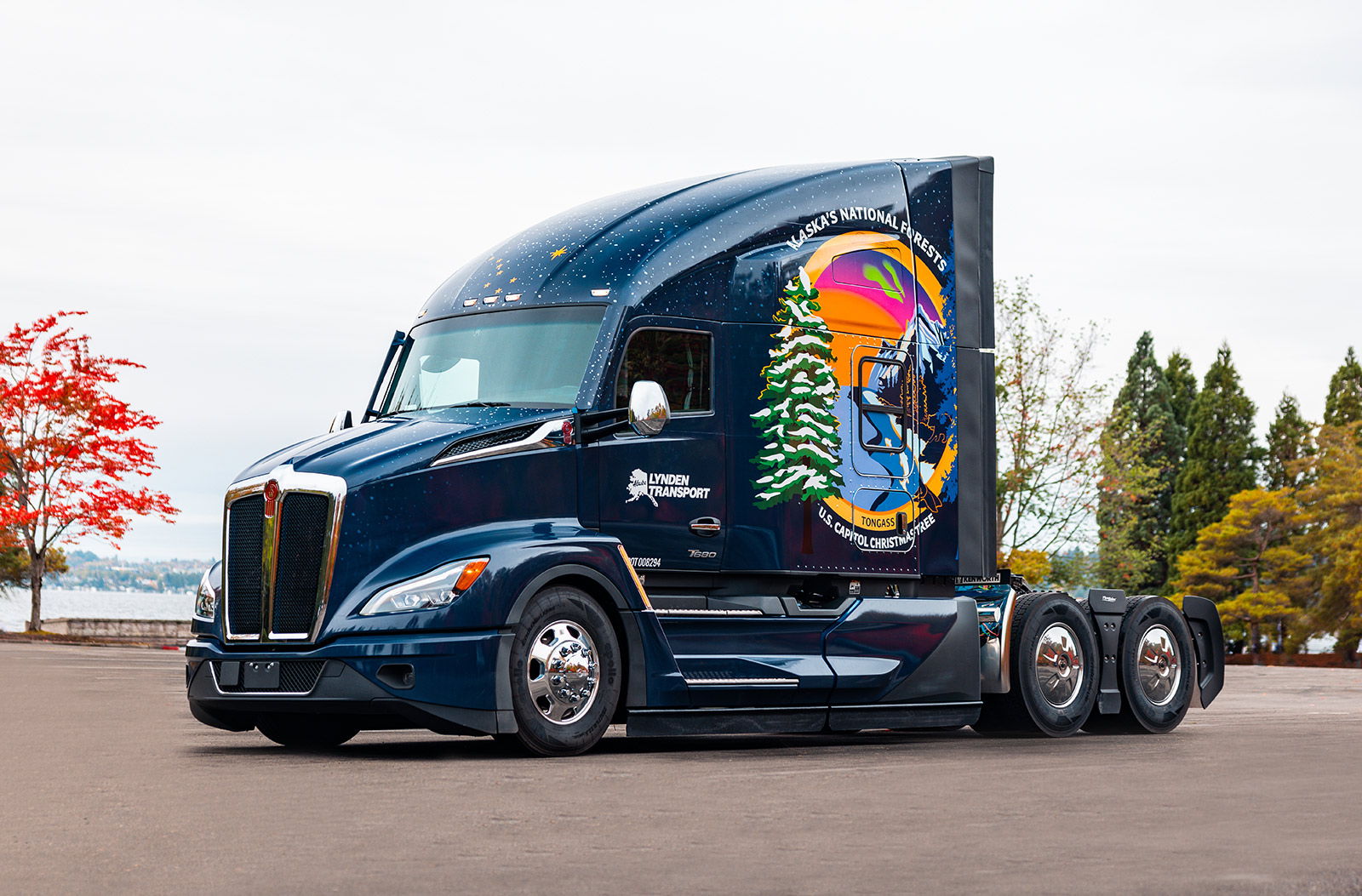 Custom Kenworth truck poised against a lake in Alaska's National Forest