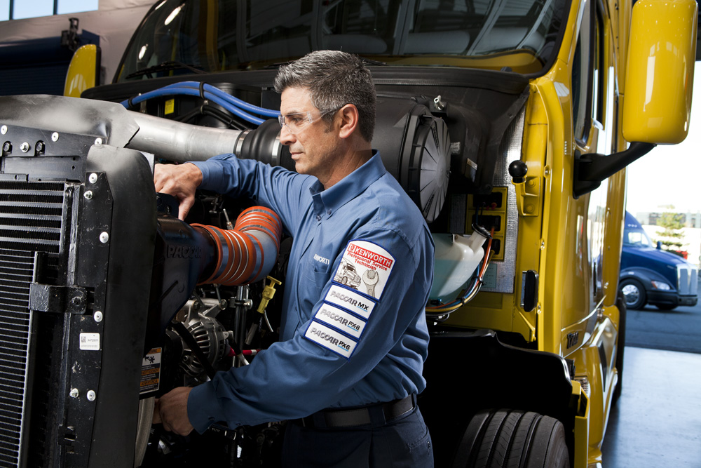 Kenworth mechanic working on truck engine